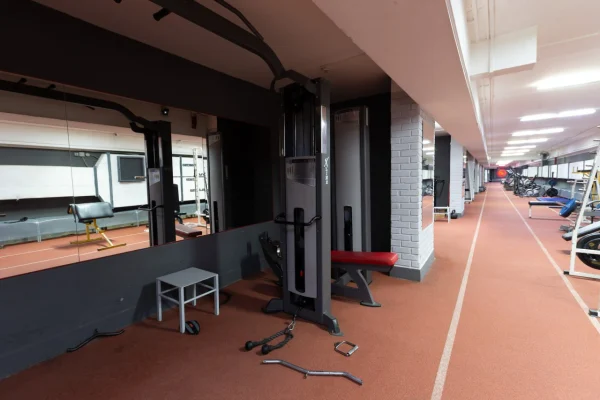 Блочный тренажер (кроссовер) и скамья в углу зала Vault Gym Гомель